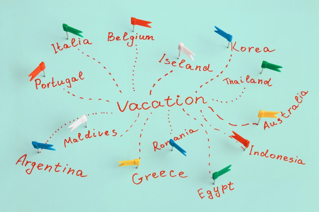 The inscription "vacation" and names of countries marked with pins. Concept of travel planning